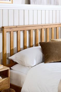 a bed with white sheets and brown pillows