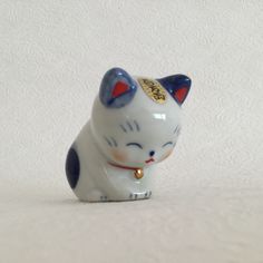 a small ceramic cat figurine on a white surface