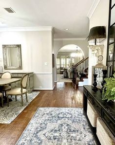 a living room filled with furniture and a rug on top of a hard wood floor