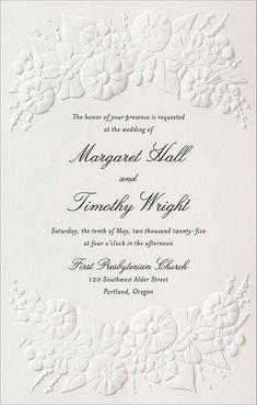 a wedding card with white flowers on the front and bottom, in black lettering that reads