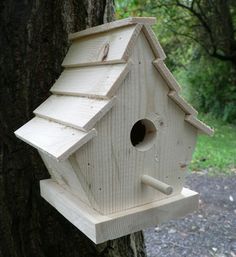 a bird house hanging from the side of a tree