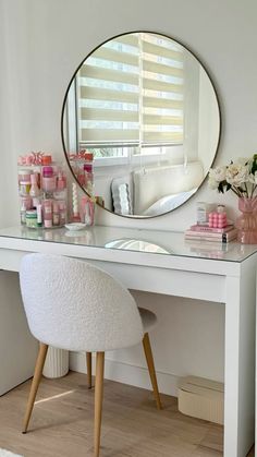 a white desk with a mirror on it and various items sitting on top of it