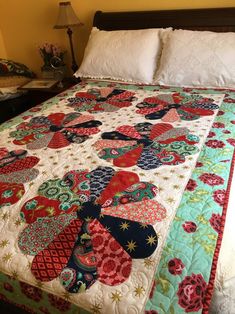 a bed with a colorful quilt on top of it