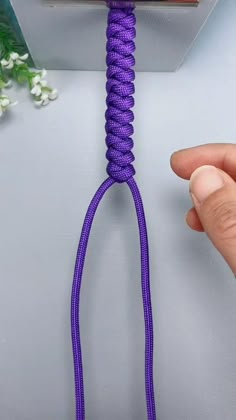 a person holding a purple rope in their hand