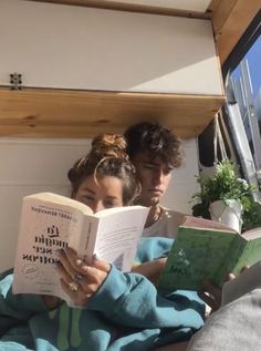 two people are reading books in the back of a boat, while another person looks on