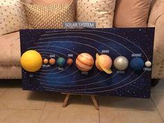 the solar system is displayed on a canvas in front of a couch with pillows and throw pillows