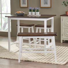 a white table with two chairs and a bowl of flowers