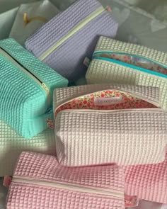 several different colored purses sitting next to each other on top of a white table