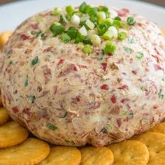 a cracker with cheese and green onions on it sitting on top of crackers