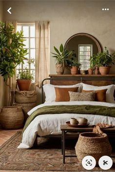 a bed room with a neatly made bed and potted plants