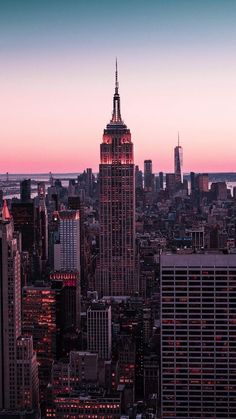 the empire building is lit up at night in new york's cityscape