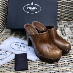 This Is A Pair Of Wooden Bottom Vintage Prada Clogs. They Are In Good Well Cared For Condition, Worn Only A Few Times And Kept In Original Box. Unused Dust Bags Included. There Are A Few Spots But They Do Not Detract, These Will Last A Lifetime. Designer Brown Heels With Wooden Heel, Luxury Leather Sole Slip-on Clogs, Luxury Leather Sole Clogs With Open Heel, Luxury Clogs With Leather Sole And Open Heel, Designer High Heel Platform Mules, Luxury Slip-on Clogs With Leather Sole, Luxury Clogs With Wooden Open Heel, Luxury Closed Toe Platform Mules, Luxury Open Toe Clogs With Leather Sole