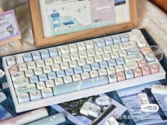 a computer keyboard sitting on top of a bed next to a wooden frame and pictures