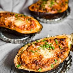 baked stuffed eggplant with sauce and parmesan cheese on the top, served in serving dishes