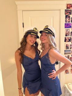 two beautiful young women dressed in sailor hats posing for a photo while standing next to each other