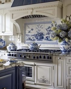 a kitchen with blue and white decor on the cabinets, stove top and counter tops