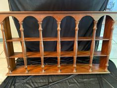 an old wooden book shelf on top of a black sheet