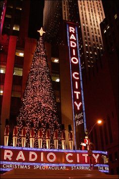 the radio city christmas tree is lit up at night