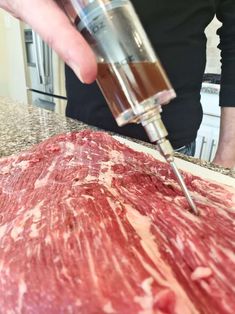 a person is using a meat grinder to cut up some meat