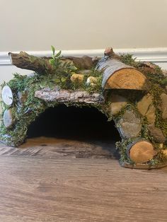 an animal house made out of logs and moss