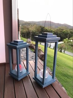 two blue lanterns sitting on top of a wooden deck