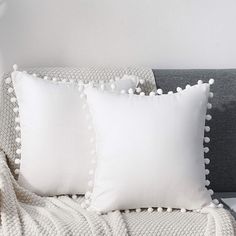 two white pillows sitting on top of a bed