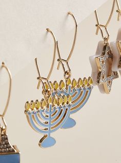 three pairs of earrings hanging from hooks with a menorah and star of david on them