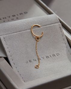 an open box with a gold key chain hanging from it's side and the word, jenny bird written on it