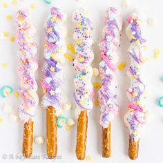 four colorful candy sticks with sprinkles on them