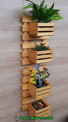 three wooden planters with plants in them hanging on the wall next to a potted plant