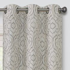 a curtain with an intricate pattern hanging on the side of a window sill in front of a window