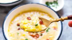 a person holding a spoon full of soup with bacon and cheese in it, while another bowl is filled with other food