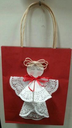 a red bag with a white angel on it hanging from the wall next to a door