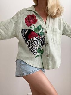 "Butterfly wing art and flower top is cool birthday gift for girlfriend.  Hand painted linen blouse with forever rose painting is pretty peace of art. Aesthetic clothes with rose and butterfly painting original there is contemporary art that can be integrated into everyday life.  CLOTHING DETAILS: Shirt brand: Zara, model Oversize. Material: 100% Linen.  Size: M (Width 20\"- 52 cm, Length 22.5\"- 57 cm) Color: Green.  Style: painted linen blouse. ABOUT PAINTS AND HAND PAINTED CLOTHES CARE FEATUR Casual Hand Painted Cotton Tops, Hand-painted Crew Neck Tops For Summer, Casual Hand Painted Crew Neck T-shirt, Artistic Hand Painted Short Sleeve T-shirt, Casual Cotton Hand Painted T-shirt, Fabric Painting On Clothes, Forever Rose, Clothing Details, Flower Tops