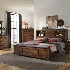 a bedroom with a bed, dresser and mirror in it's centerpieces