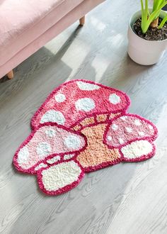 a pink couch sitting next to a mushroom rug on top of a hard wood floor