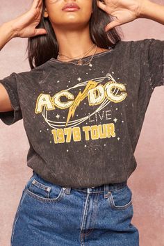 Mineral-washed graphic t-shirt. Vintage-style "AC/DC Live 1978 Tour" text with star graphics. Round neckline. Short drop-shoulder sleeves. Loose fit. 100% Cotton. Imported top designed and printed in Los Angeles, CA. Officially licensed AC/DC merchandise. Not eligible for discounts. Acid Wash Band Merch T-shirt With Graphic Print, Washed Black Band Merch T-shirt With Graphic Print, Edgy Washed Black T-shirt With Letter Print, Edgy Acid Wash Short Sleeve T-shirt, Trendy Acid Wash T-shirt For Concert, Summer Washed Black Tops With Letter Print, Summer Tops In Washed Black With Letter Print, Crew Neck Graphic Print Top For Concert, Trendy Graphic Print Tops For Music Festival