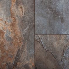 a close up view of a stone floor with brown and gray colors on the tiles