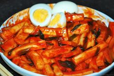 an egg is on top of some fries in a bowl with sauce and ketchup