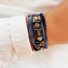 Elegant Boho Chic bracelet in worn navy blue and silver. This bohemian and hippie style bracelet is at the same time very elegant and youthful. It is made up of a ribbon in a gradient blue tone and decorated with various Greek porcelain and steel charms. It is very easy to put on by wrapping it around your wrist three times and then tying it at the back. It is ideal to give a boho chic touch to your outfit. In addition, you can also use it as a necklace or choker, the result is ideal and very fl Elegant Adjustable Wrap Bracelet For Festival, Elegant Blue Wrap Bracelet As A Gift, Elegant Blue Wrap Bracelet As Gift, Bohemian Adjustable Wrap Bracelet For Party, Elegant Handmade Blue Friendship Bracelets, Elegant Handmade Blue Wrap Bracelet, Elegant Hand Wrapped Festival Wrap Bracelet, Elegant Festival Wrap Bracelet, Blue Silk Ribbon