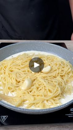 someone is cooking pasta in a pan on the stove