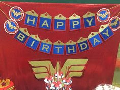 a birthday cake with wonder woman decorations on it and a banner that says happy birthday