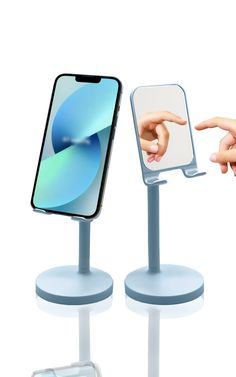 two cell phones on pedestals with one pointing at the other's phone screen