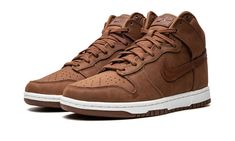 The Women’s Nike Dunk High Premium “Pecan” is a women’s-exclusive colorway of the popular sneaker with a mostly brown design.  A versatile, casual look for the Dunk High, the “Pecan” colorway features a monochromatic burnt orange upper with tonal overlays and Swoosh branding.  A debossed “Nike” logo is found on the tongue along with a classic Swoosh emblem.  Underfoot, a white rubber midsole and Pecan-colored rubber outsole finish off the look.  Release date: October 12, 2022 Black And Brown Jordan 1, Brown Jordan 1 Outfit, High Top Dunks Outfit, Brown Jordan 1, High Top Dunks, Nike Dunk High Premium, Veja Sneakers, Adidas Spezial, Nike Dunk High