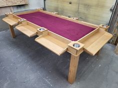 a pool table made out of wood and purple carpet