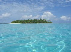 an island sits in the middle of clear blue water