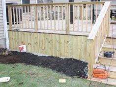 a wooden deck next to a small yard