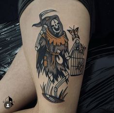 a person with a tattoo on their thigh holding a bird in a cage and wearing a hat