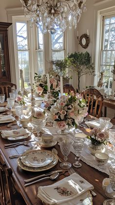 a dining room table is set with dishes and place settings