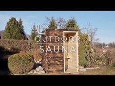 an outdoor sauna with the words out door in front of it and bushes around it